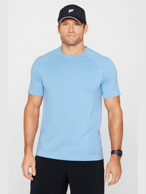 Fabletics The Training Day Tee light blue seamless compression short sleeve shirt with raglan sleeves and crew neck for men's running and training